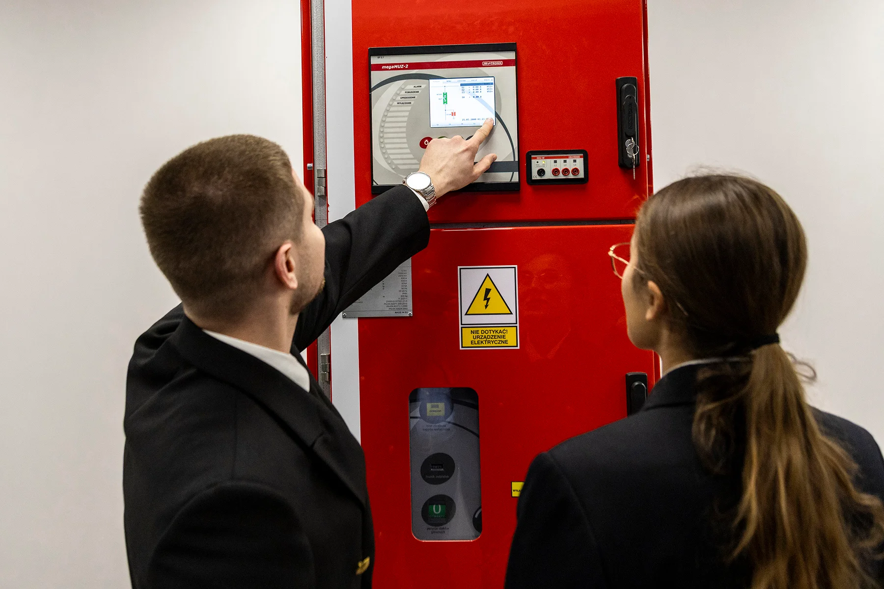 Studenci mechatroniki pry urządzeniu