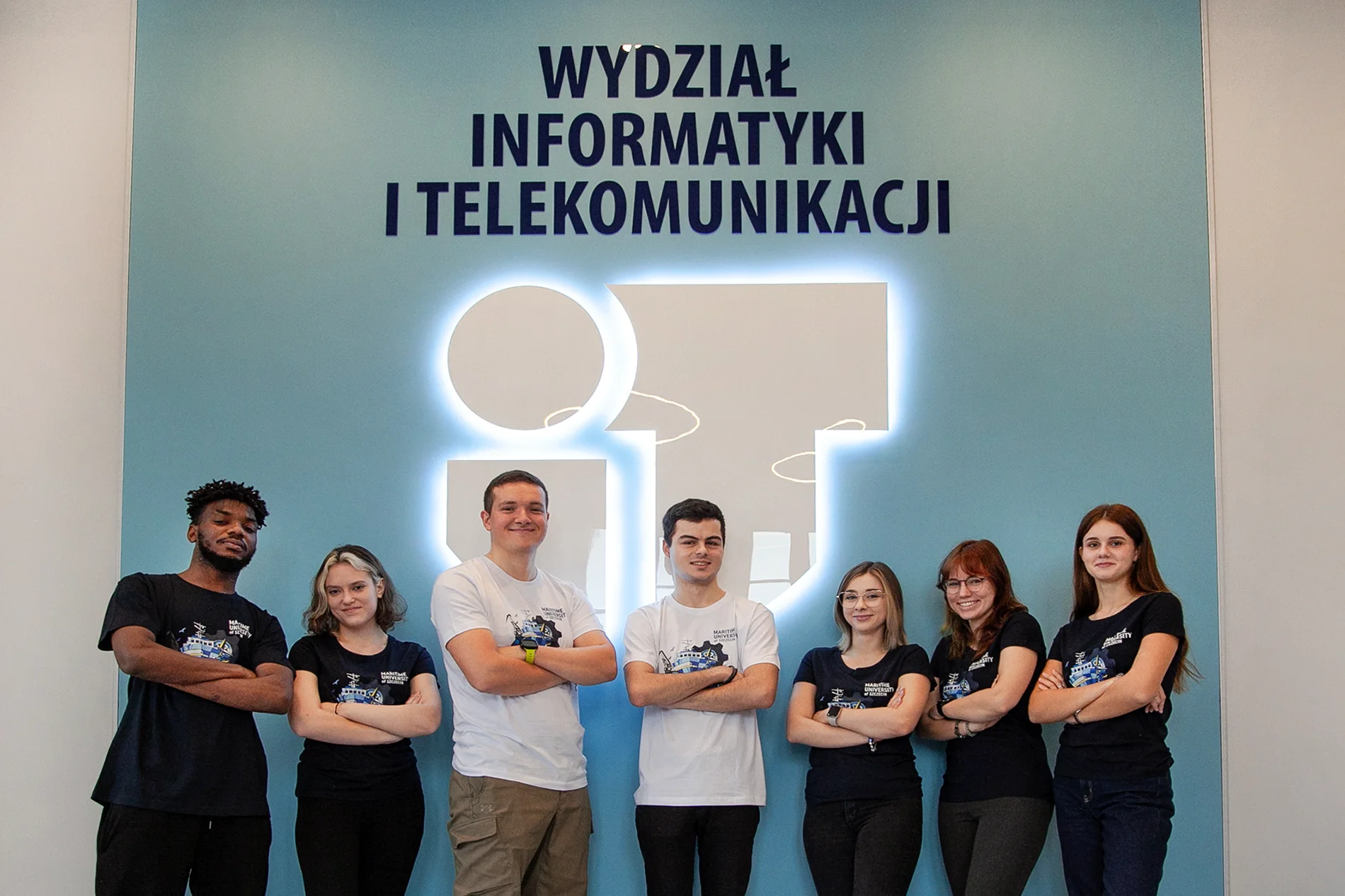 Siedmioro studentów PM obu płci  w sali pod napisem Wydział Informatyki i Telekomunikacji 