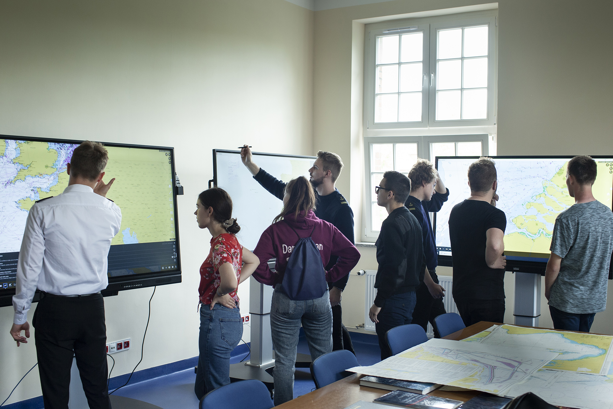 Studenci i uczniowie szkól średnich przy stołach nawigacyjnych