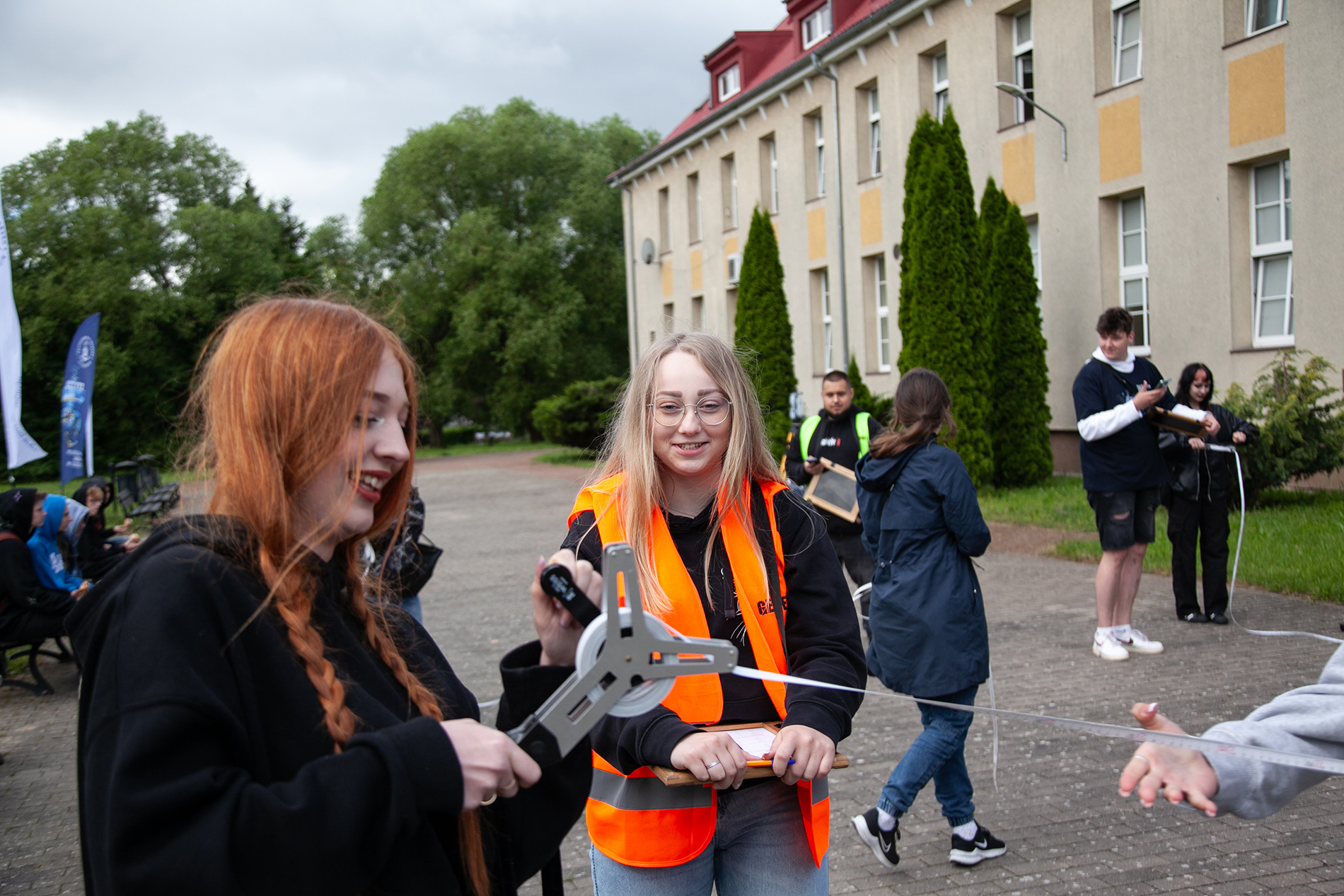 Uczennica i studentka podczas konkurencji zwijania taśmy na czas na Geopikniku