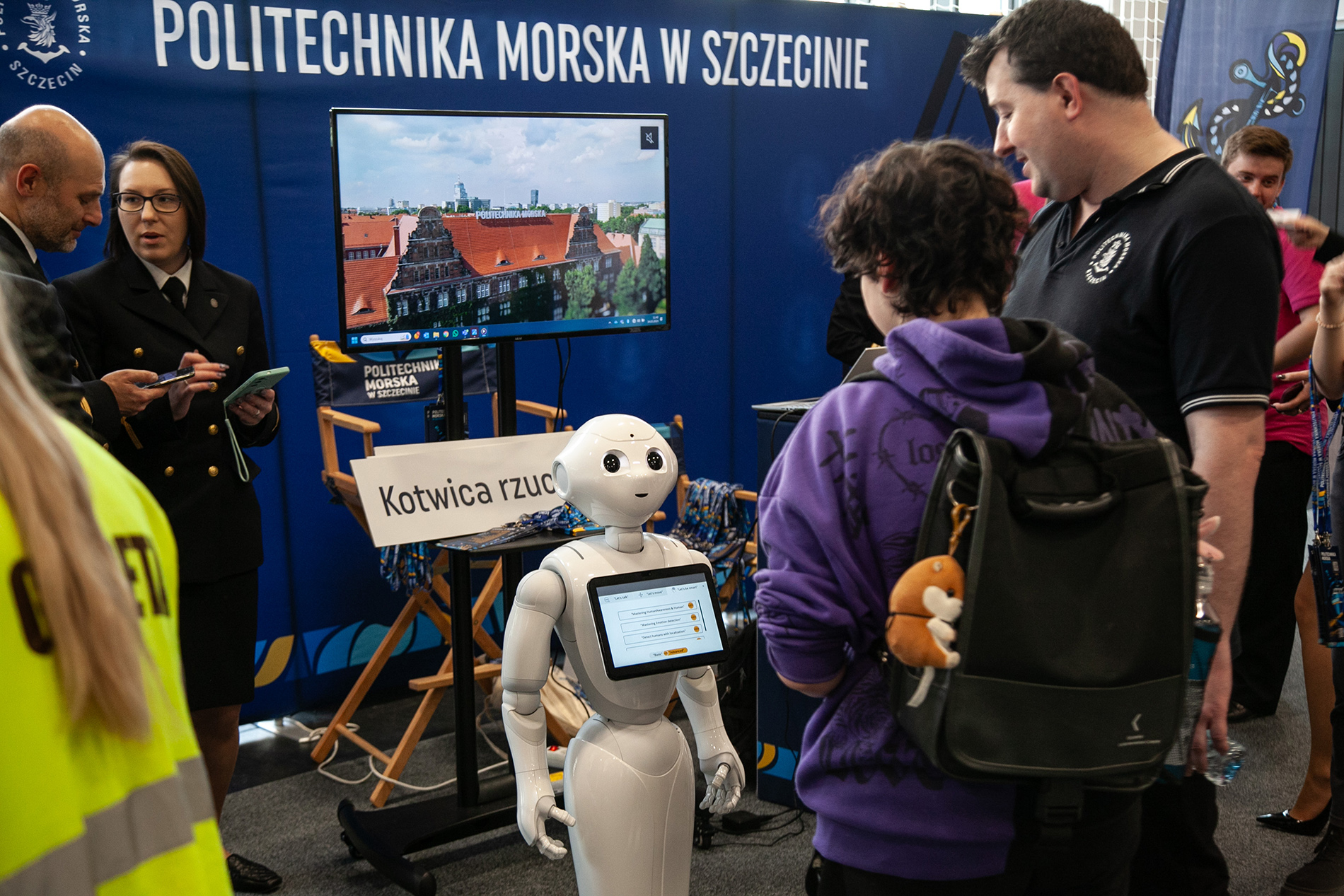 Studenci i pracownicy PM, robot oraz uczniowie szkół ponadpodstawowych na stoisku Politechniki Morskiej na targach w  Szczecinie